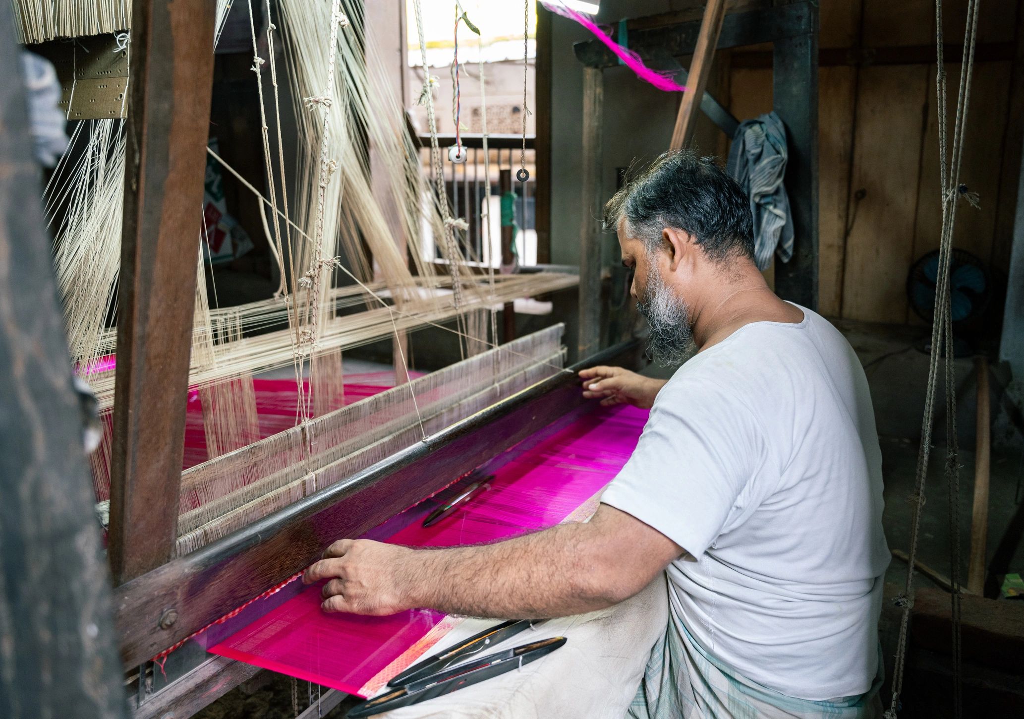 Artisan using a handloom to create textile fabric