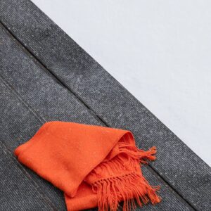 Orange scarf on wooden bench in winter