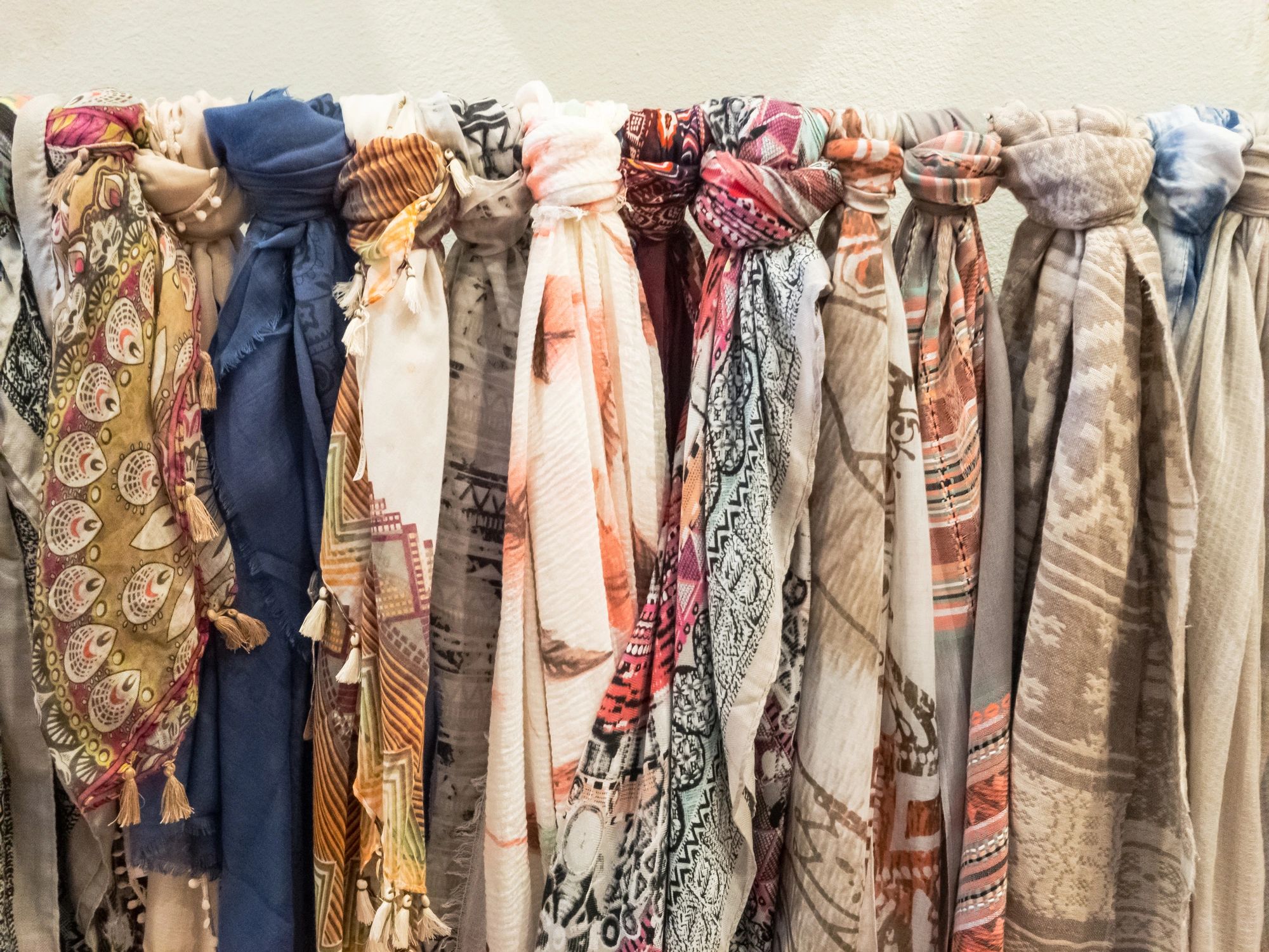 Row of boho chic scarves and wraps hanging in a boutique display